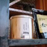 Close-up of coffee products on a wooden shelf, ideal for cafes or loft-style kitchens.